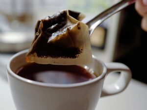 a tea bag on a spoon, being removed from a teacup